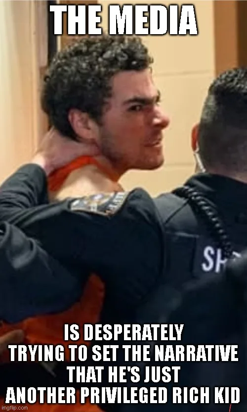 A man with curly dark hair, wearing an orange jumpsuit, is being held by a police officer in a dark uniform. The officer's…