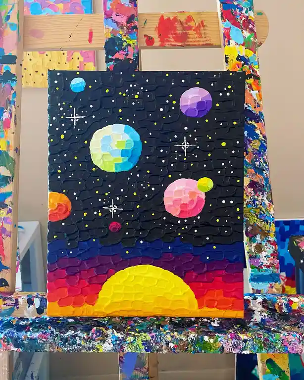 A thickly textured, colorful painting on canvas depicts a whimsical space scene with multiple brightly colored planets and…