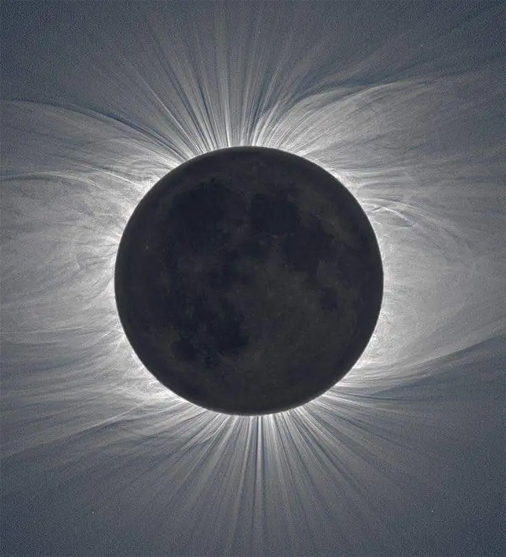 a photograph of a total solar eclipse where the moon completely blocks the sun's disk, revealing the sun's faint, wispy…