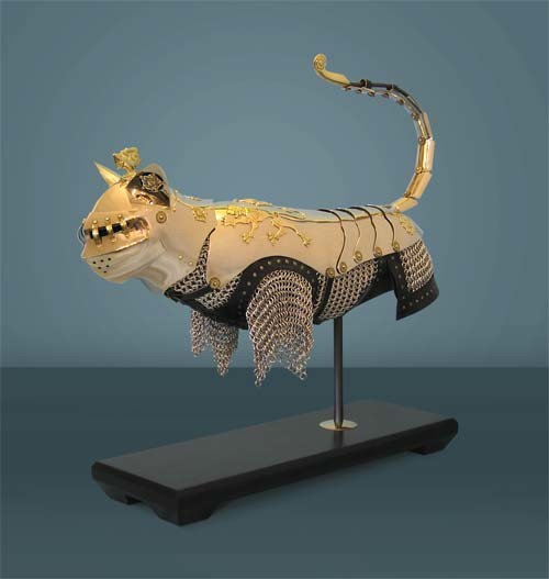 a cat statue is fully encased in ornate, gold-accented armor featuring chainmail on its lower body and articulated plates…