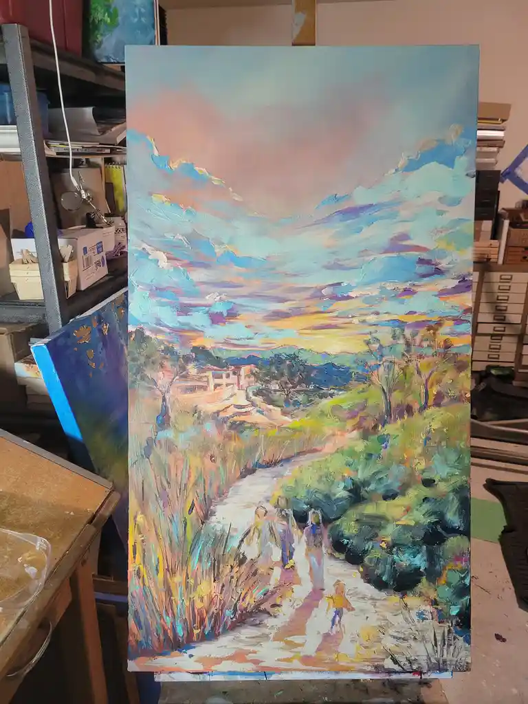 A large, colorful oil painting of a winding path through a hilly, tree-lined landscape under a vibrant sky is propped up in…