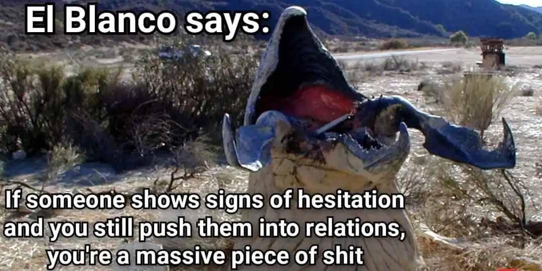 A large, open-mouthed, blue and white creature resembling a whale or monster is shown in a desert landscape with mountains…