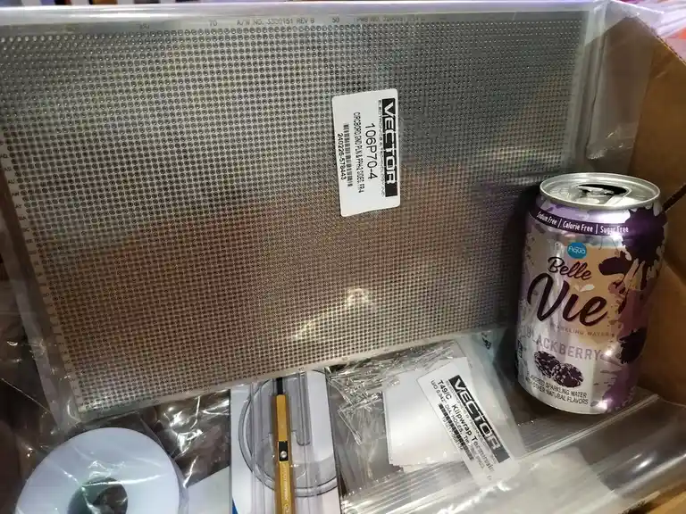 A close-up photo shows a can of Belle Vie Blackberry Sparkling Water sitting next to an electronics kit containing a…