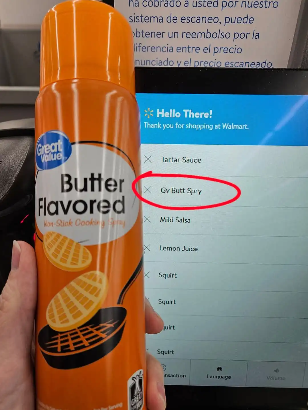 A hand holds an orange can of Great Value Butter Flavored Non-Stick Cooking Spray in front of a Walmart self-checkout…