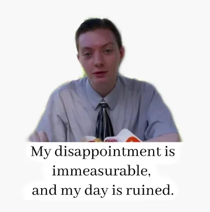 A person in a light-colored shirt and tie sits at a table with fast food wrappers, looking visibly disappointed. The…