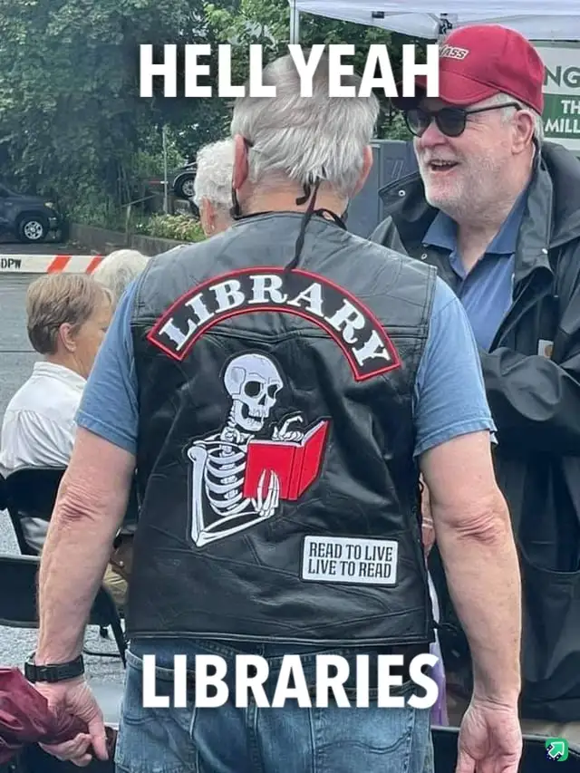 A man wearing a black leather vest with a skeleton reading a red book, the word 'LIBRARY' arched above it and 'READ TO LIVE…