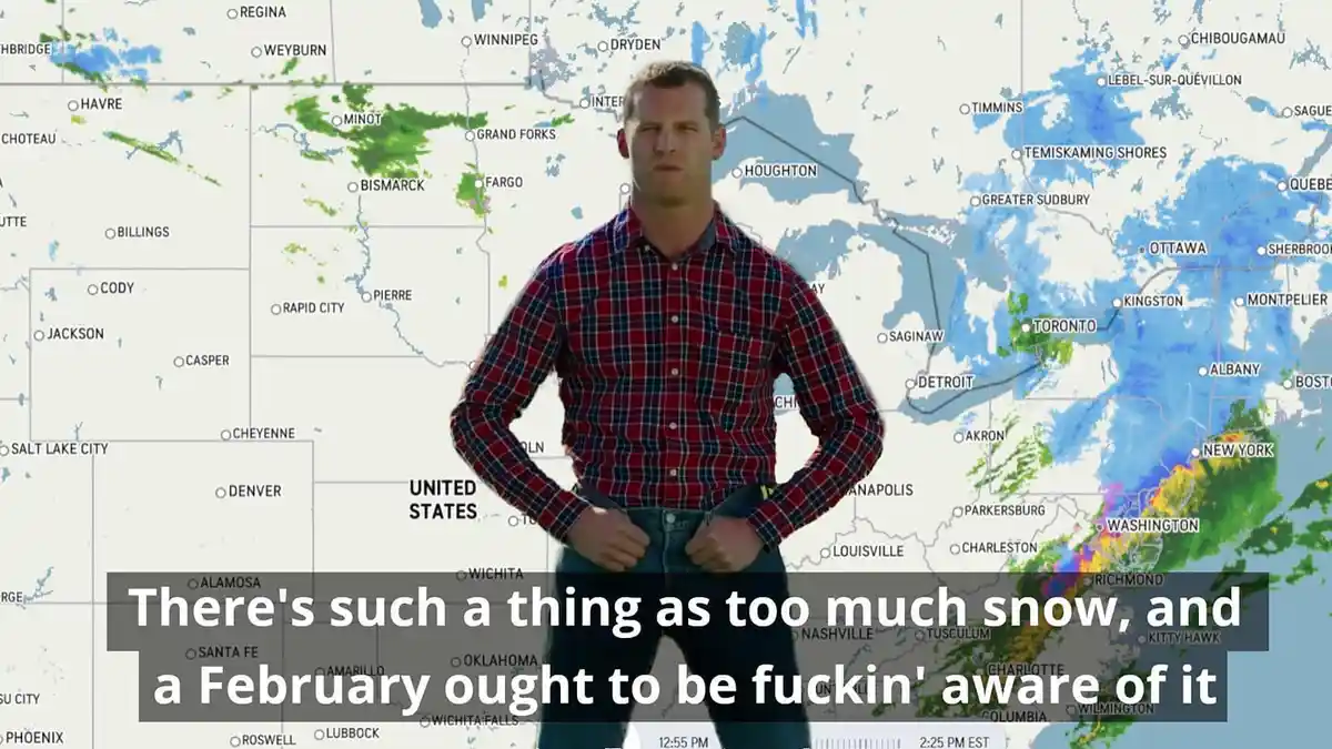 A man in a red plaid shirt stands with hands on hips in front of a weather map showing heavy snowfall across North America…