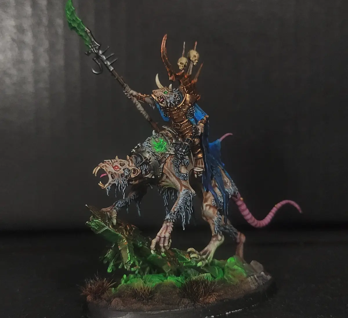 A highly detailed, painted miniature of a fantasy rat-like warrior with horns and skulls on a helmet, riding a skeletal…