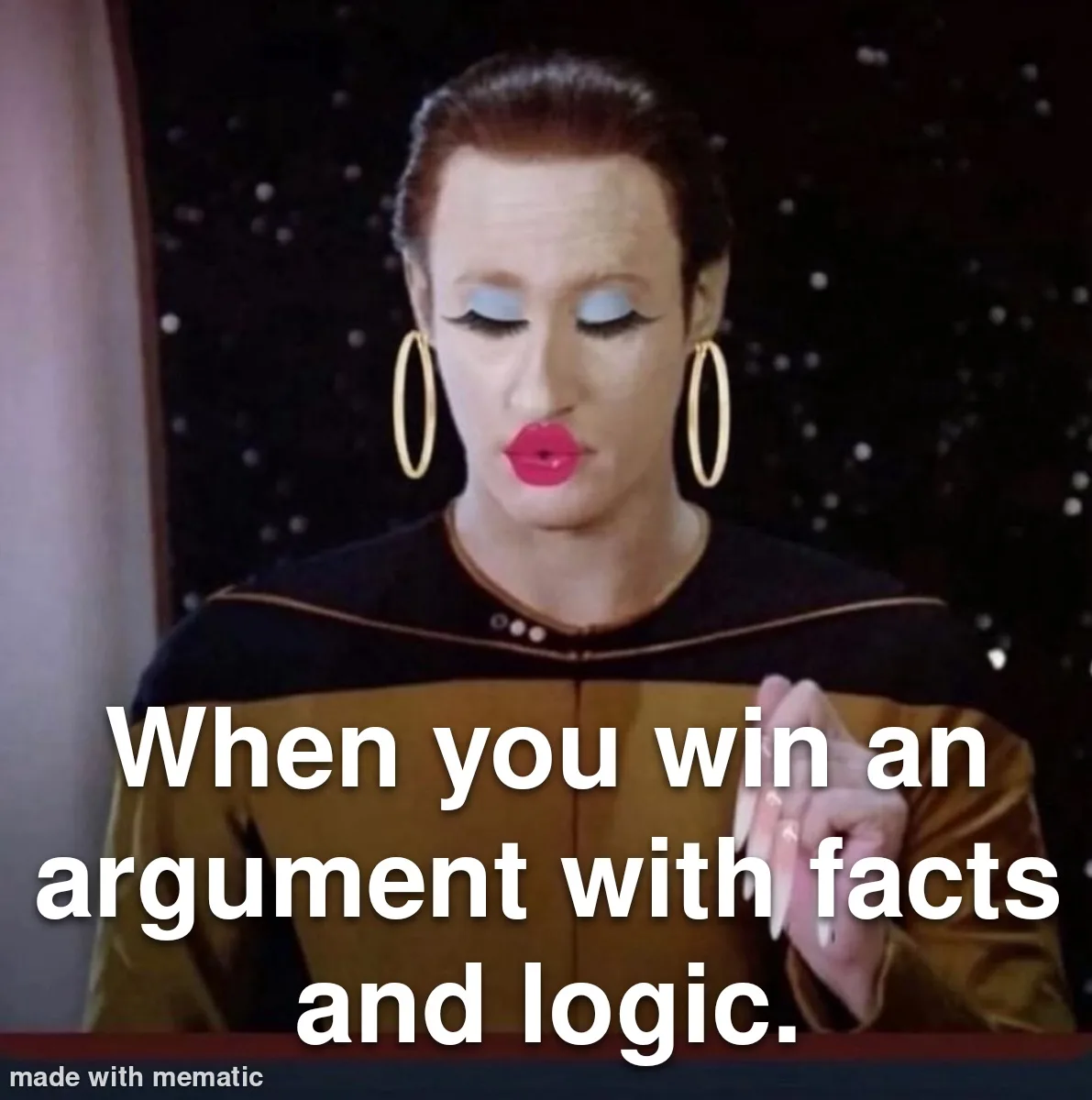 A woman in a Star Trek uniform with dramatic makeup and large hoop earrings looks down with a smug expression while holding…