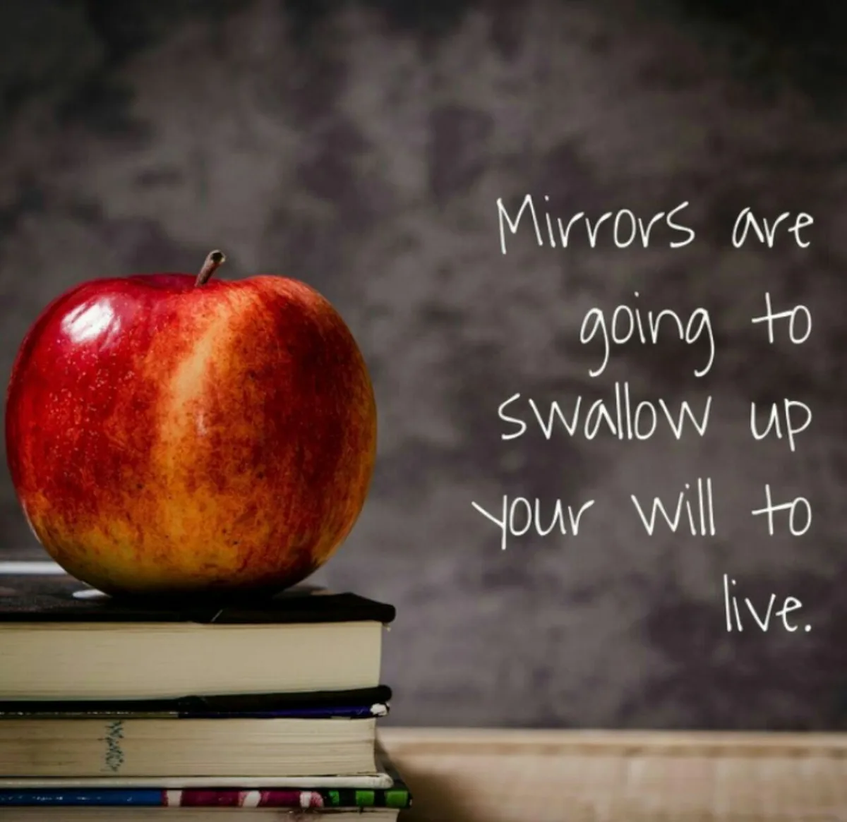A shiny red apple sits atop a stack of books against a dark, textured background. White handwritten text overlaid on the…