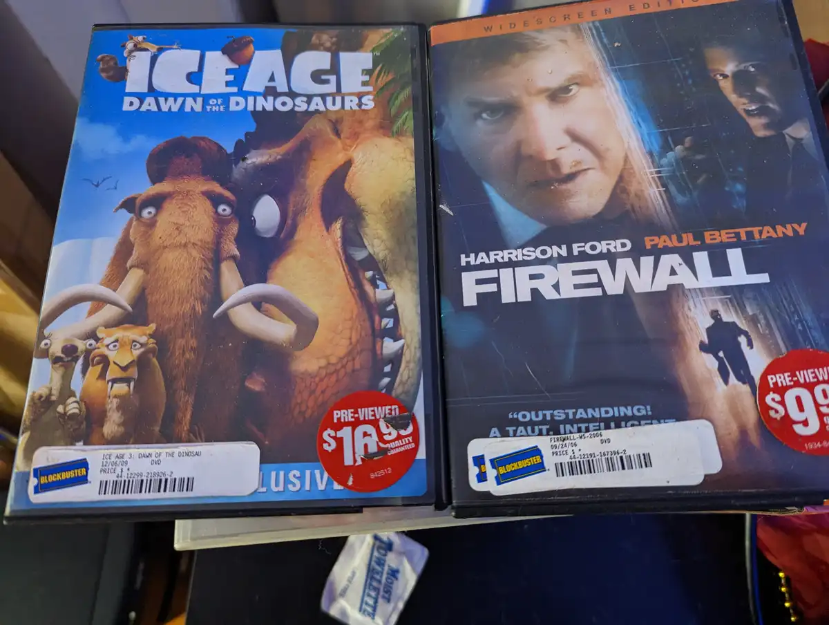 Two side-by-side DVD covers: 'Ice Age: Dawn of the Dinosaurs' with cartoon animals and 'Firewall' with Harrison Ford and…