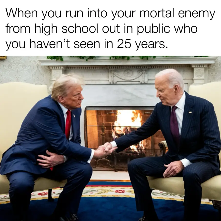Two men in suits sit facing each other on chairs in front of a fireplace, shaking hands with serious expressions. The text…