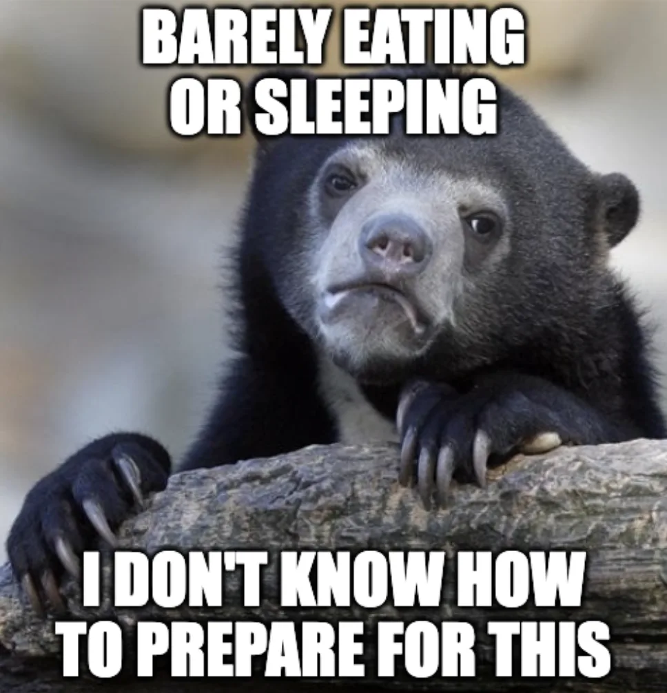 A close-up photo of a sad-looking spectacled bear resting its head on a log, with white bold text overlaid at the top…
