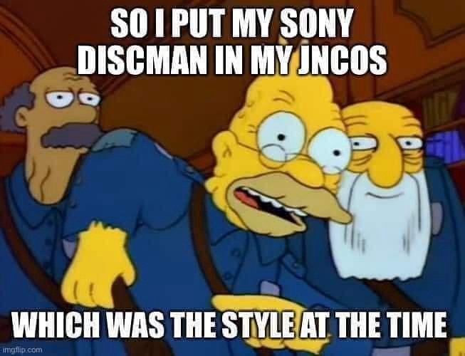 Three Simpsons characters in blue prison uniforms, with the central character looking shocked and wide-eyed. The text…