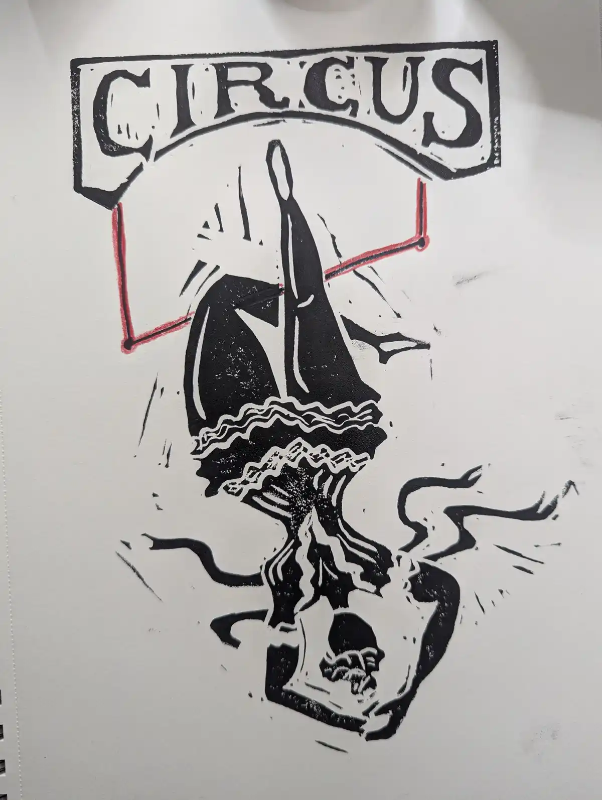A black-and-white linocut-style illustration shows a circus performer hanging upside down from a red bar, wearing a frilly…