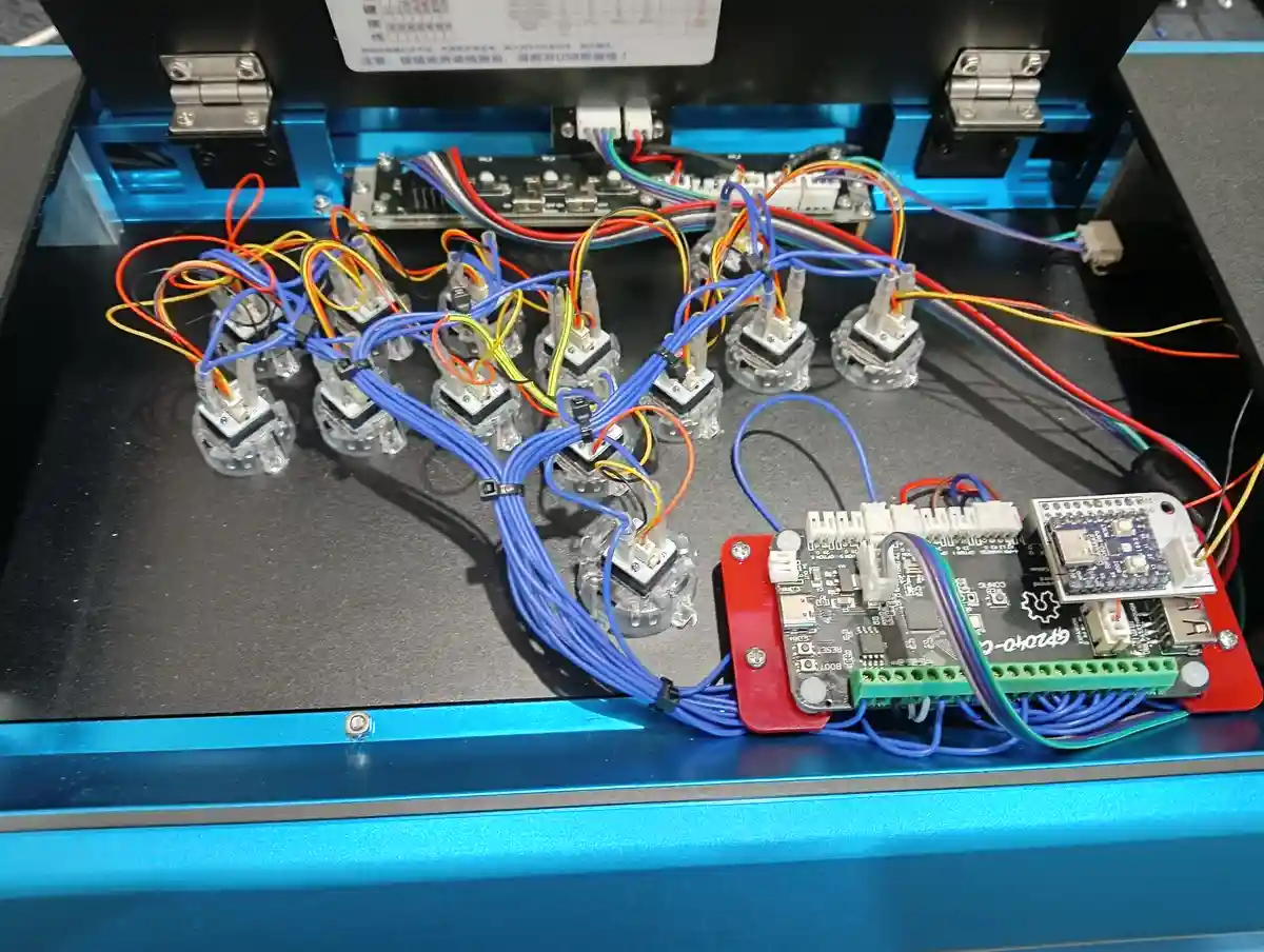 The image shows the internal wiring of an electronic device, likely a gamepad, with 12 transparent joysticks arranged in a…