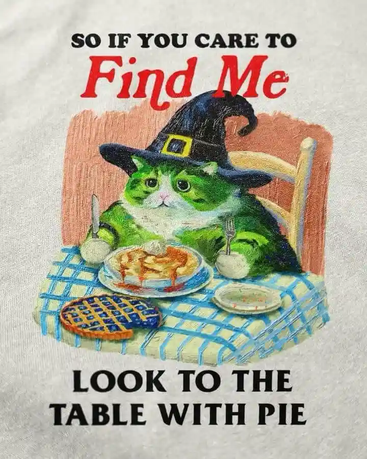 A green and white cat wearing a black witch's hat sits at a table with a blue checkered tablecloth, holding a knife and…