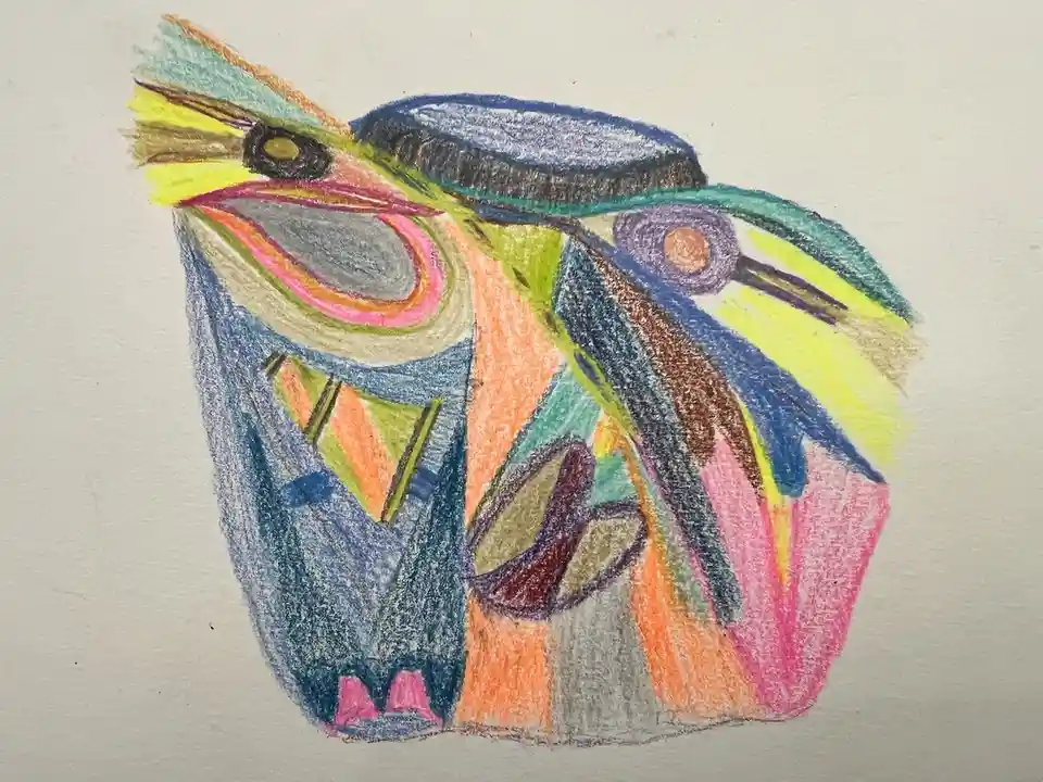 A colorful crayon drawing of a stylized, abstract creature with a large open mouth, sharp teeth, and a single visible eye…