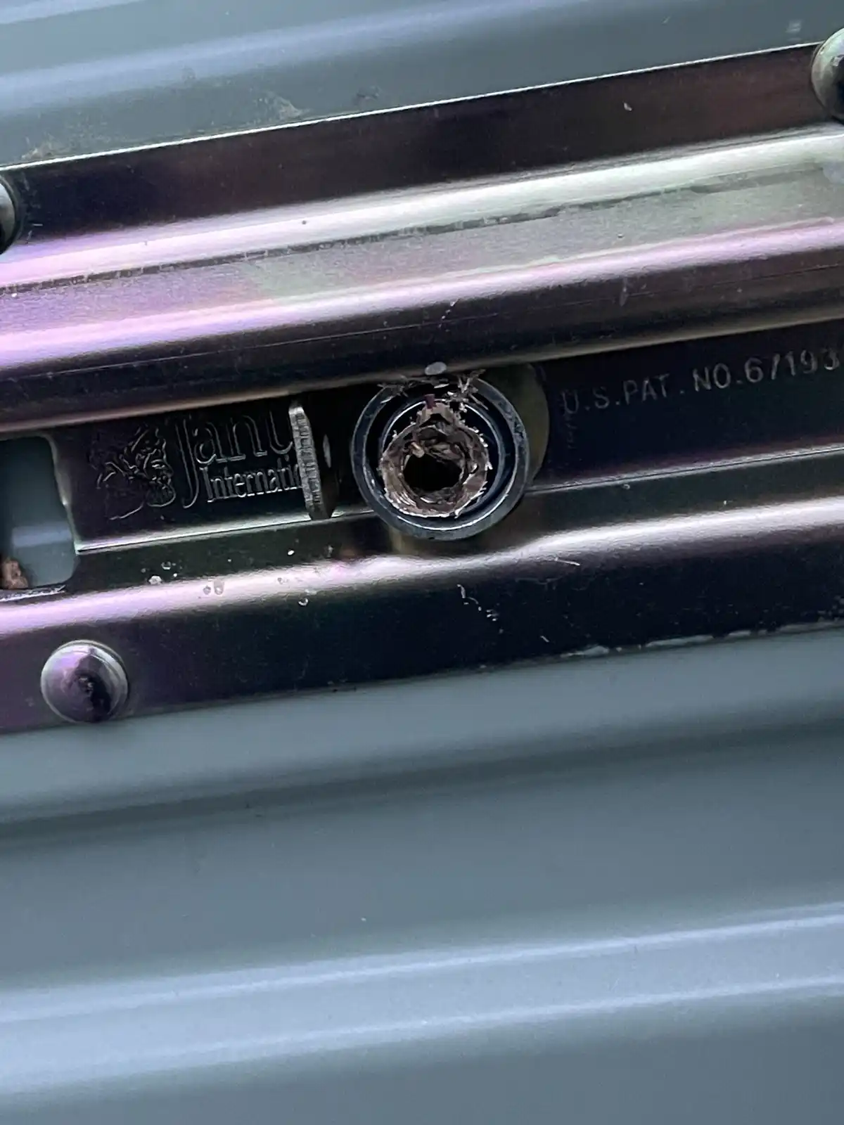 A close-up photo shows a damaged, chewed-through metal component on a Janu International branded device, with the text 'U.S…