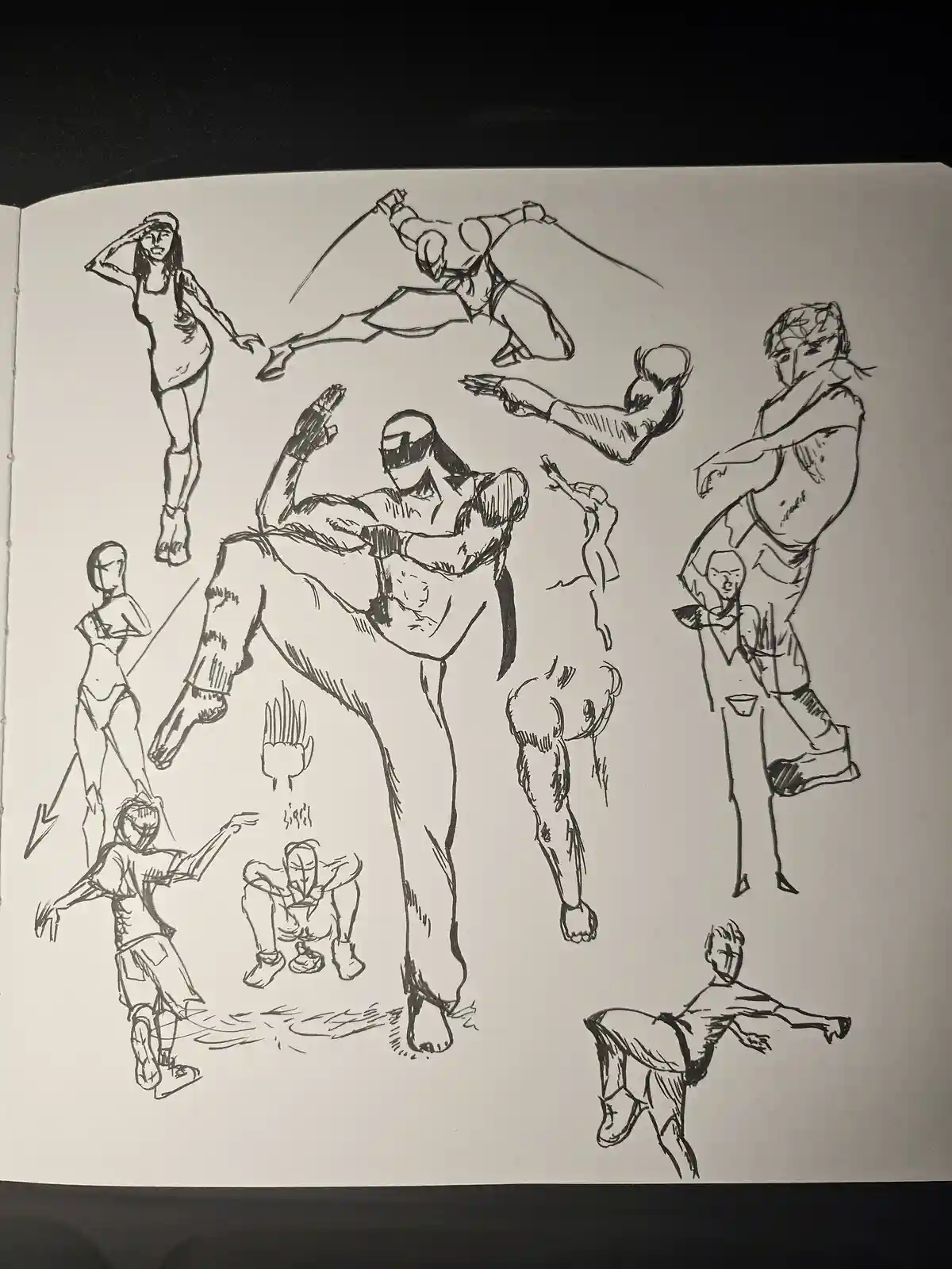 A black-and-white sketchbook page filled with various dynamic human figure drawings, including martial arts poses…