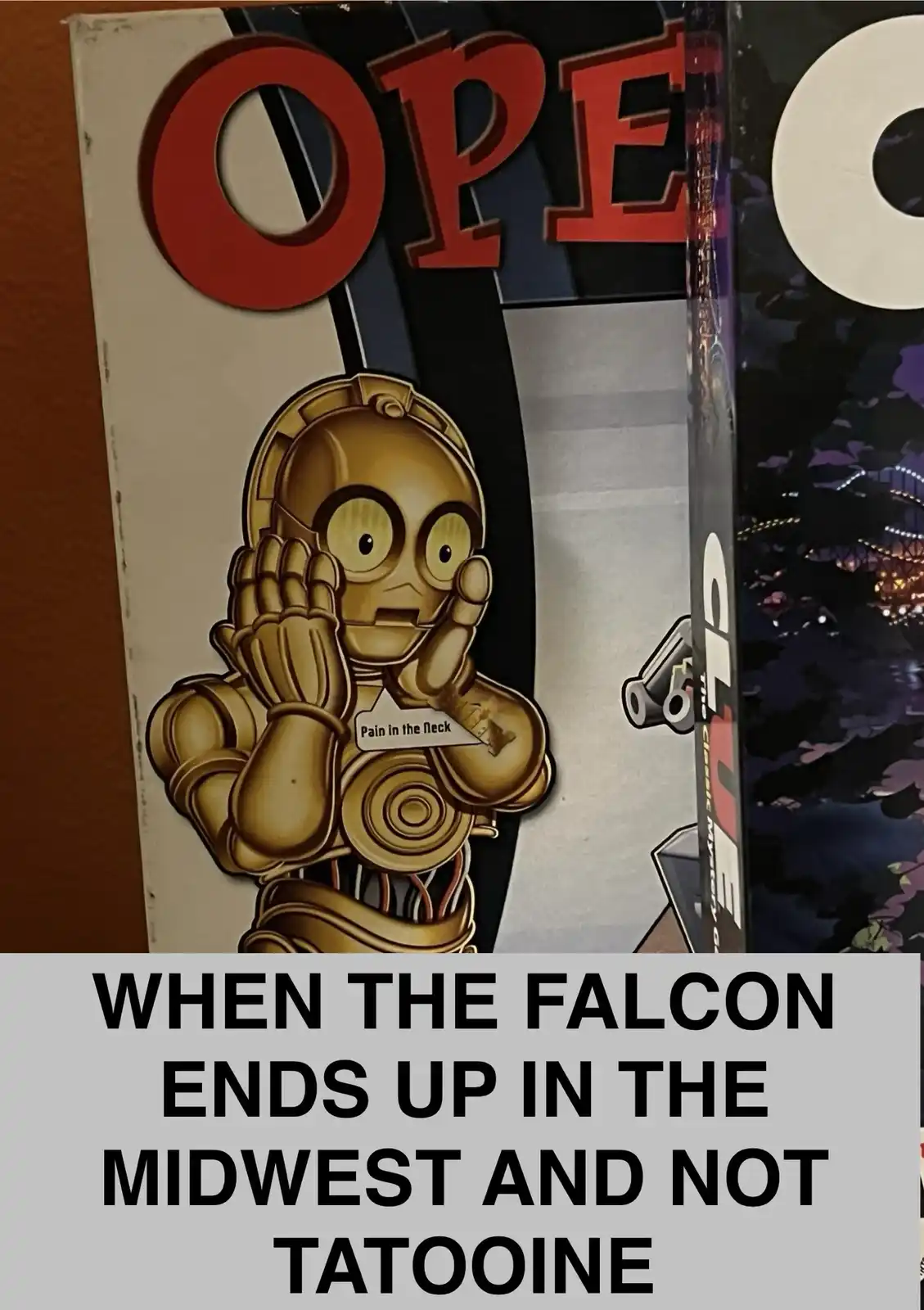 A close-up of a Star Wars-themed box featuring a cartoon C-3PO with a 'Pain in the Neck' label on his chest, set against a…