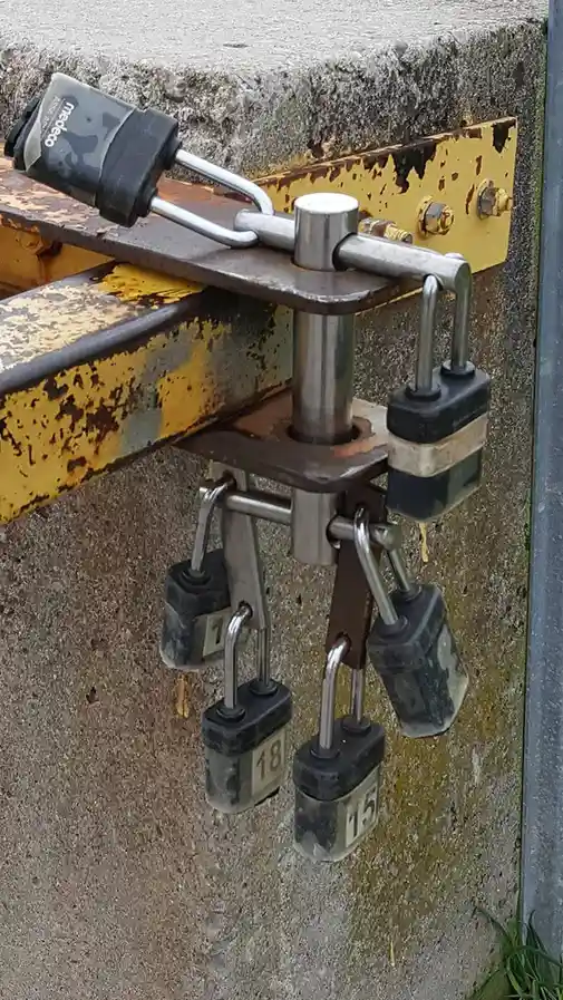 A heavy-duty metal hitch mechanism is secured with multiple black padlocks, including one labeled 'Medeo' and others…