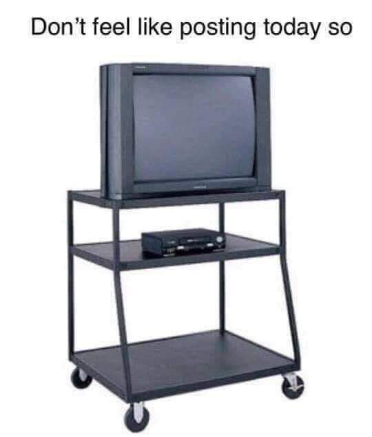 An old CRT television sits on a black, three-tiered rolling cart with wheels. The top shelf holds the TV, the middle shelf…