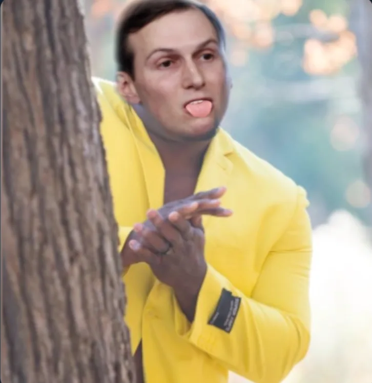 a man in a bright yellow blazer peeks from behind a tree trunk, sticking his tongue out and gesturing with his hands as if…