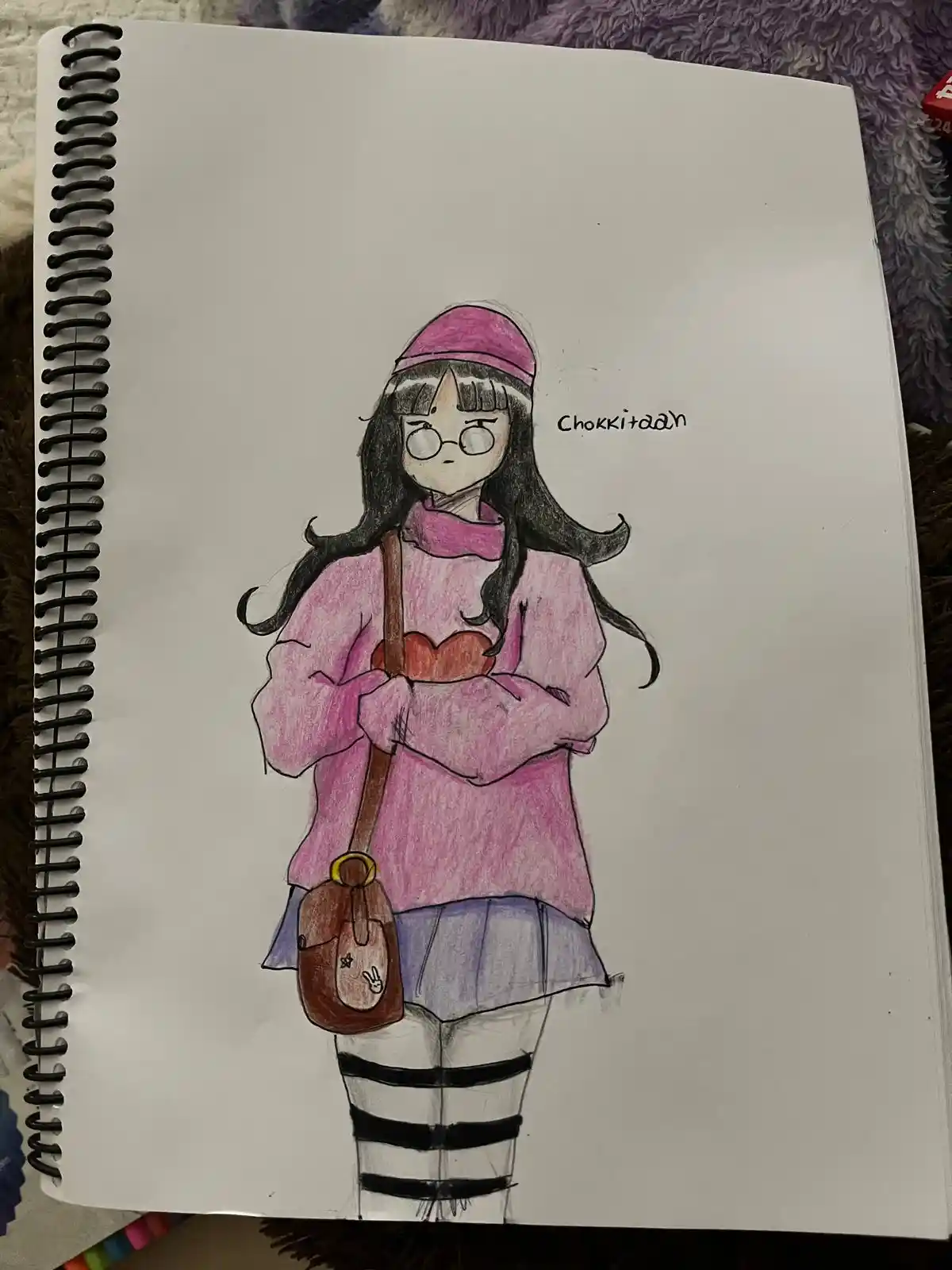 A hand-drawn anime-style girl in a pink hoodie, hat, and striped leggings, holding a heart-shaped object and a small brown…