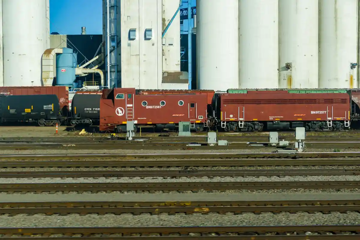 A photograph of two red BNSF Railway rotary snow plow locomotives, numbered BN972561 and BN972577, parked on parallel tracks…