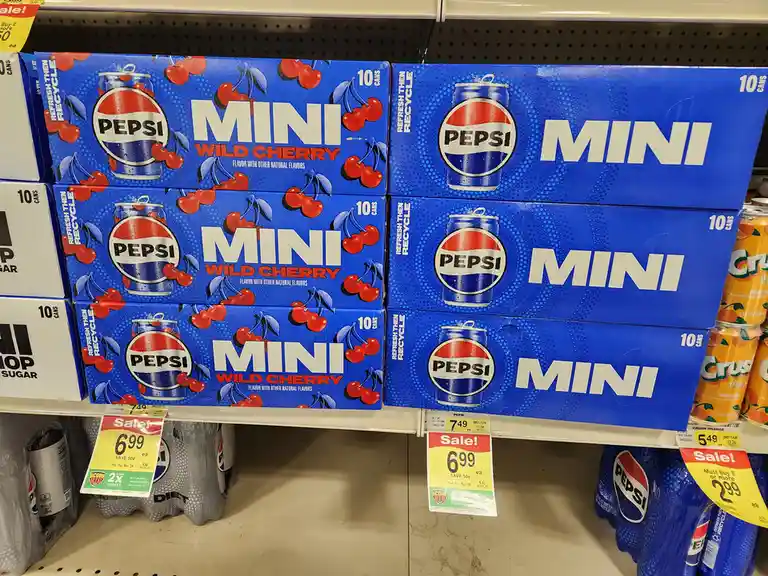 A grocery store shelf displays multiple blue boxes of Pepsi Mini Wild Cherry soda, each labeled with the brand logo and…
