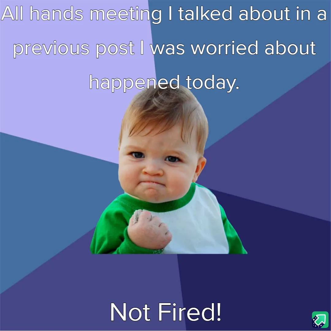 A baby with a green and white shirt makes a determined, slightly angry face while holding a clenched fist. The background is…