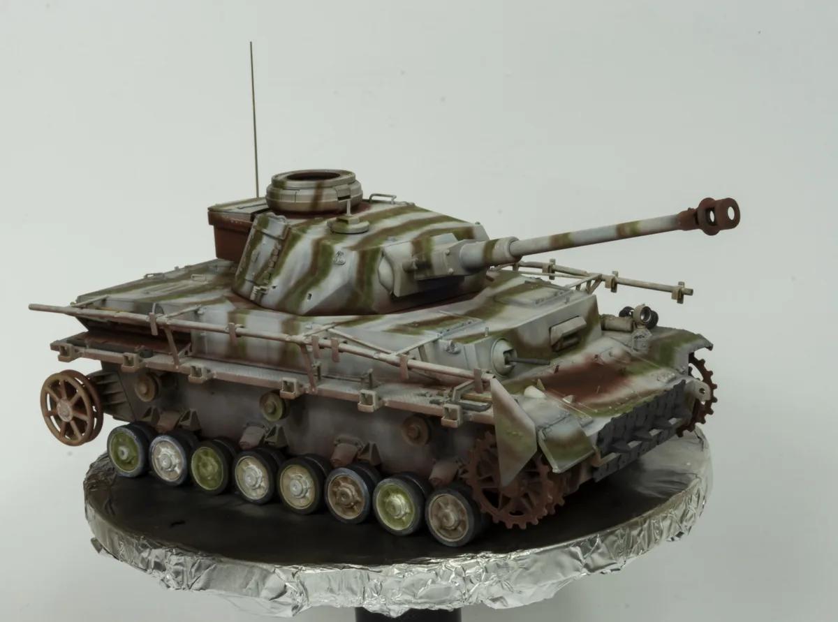 a highly detailed scale model of a German Panzerkampfwagen IV tank, painted with a weathered camouflage pattern of green…