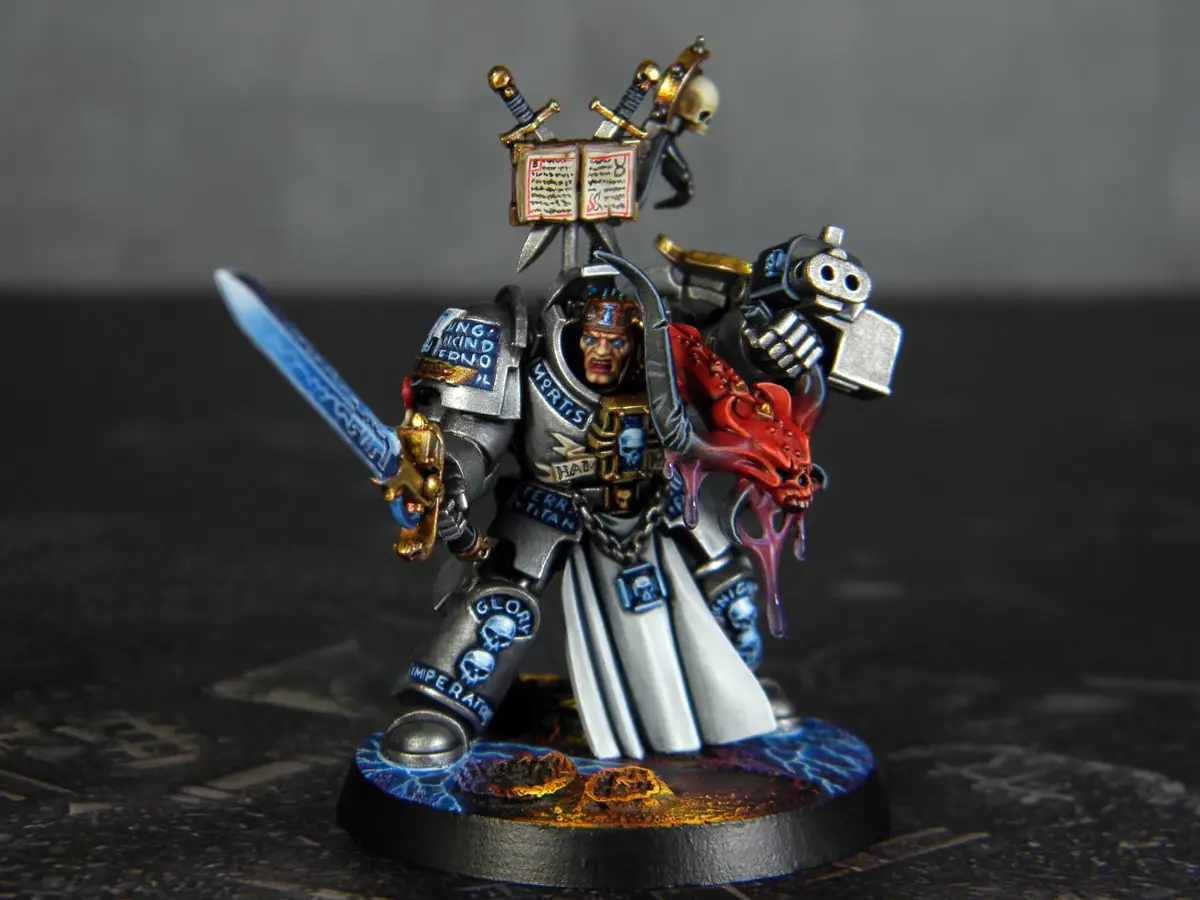 A highly detailed, painted miniature of a Space Marine from the Warhammer 40,000 universe, standing on a circular base with…