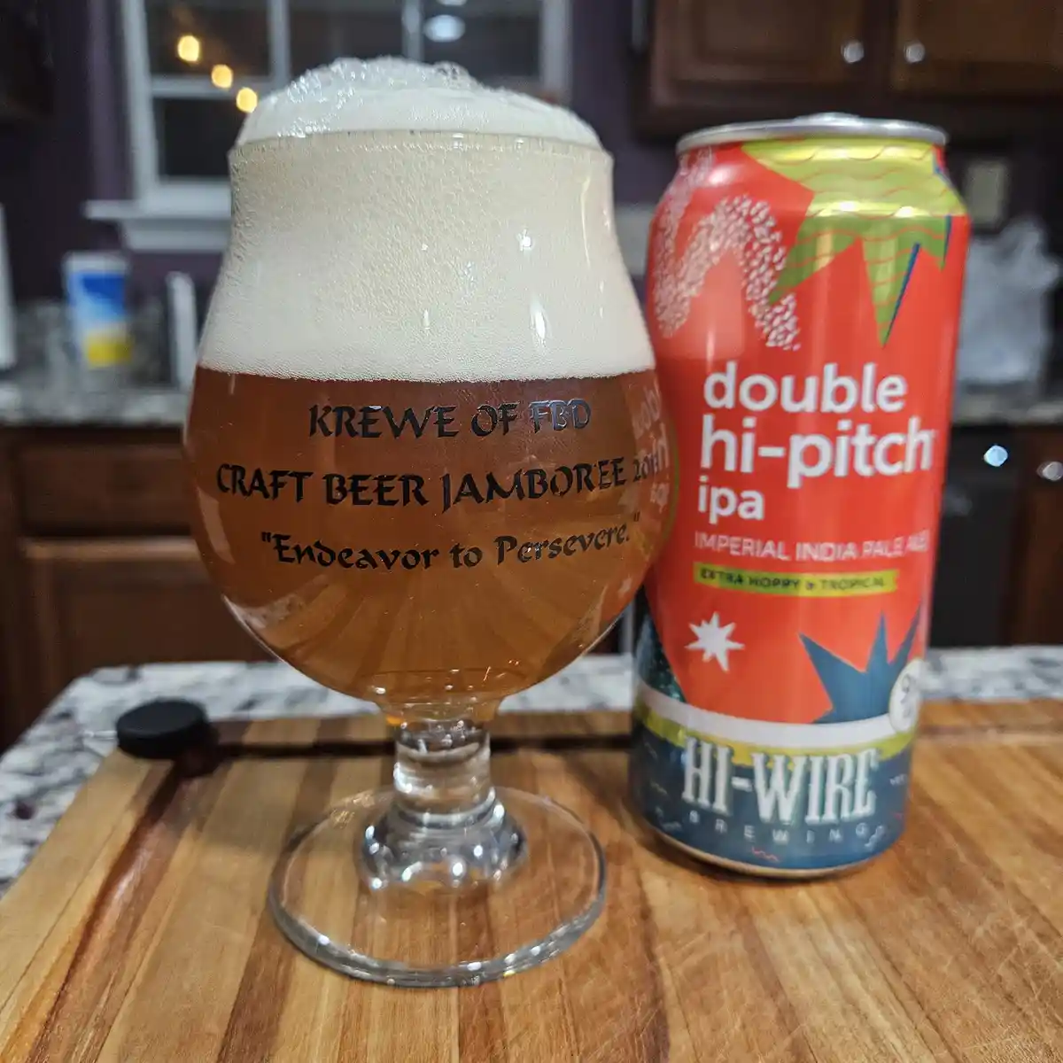 A beer glass filled with amber beer and a thick white head sits next to a can of Hi-Wire Brewing's 'Double Hi-Pitch IPA'…