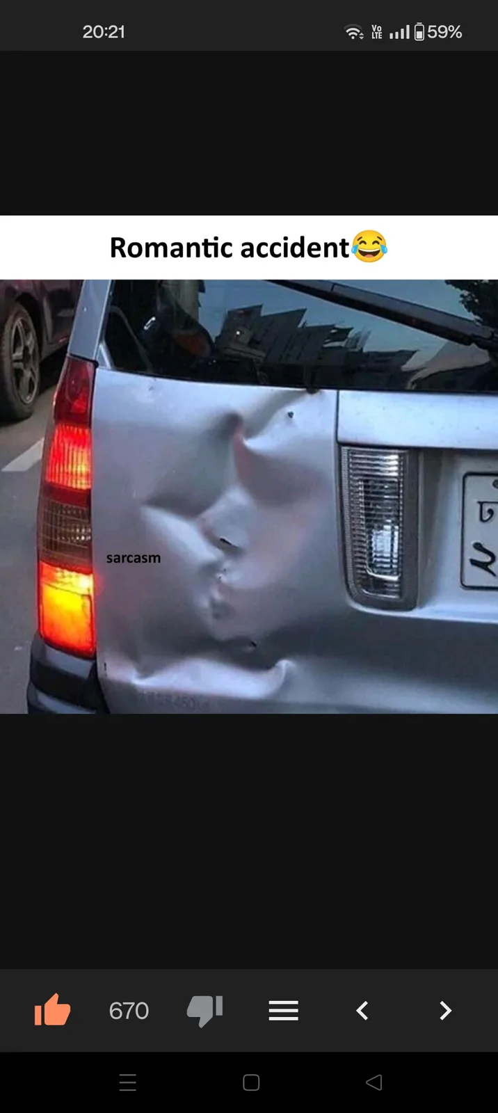 A close-up photo of a silver car's rear door showing a large, dented, and crumpled area that resembles a face with a nose…