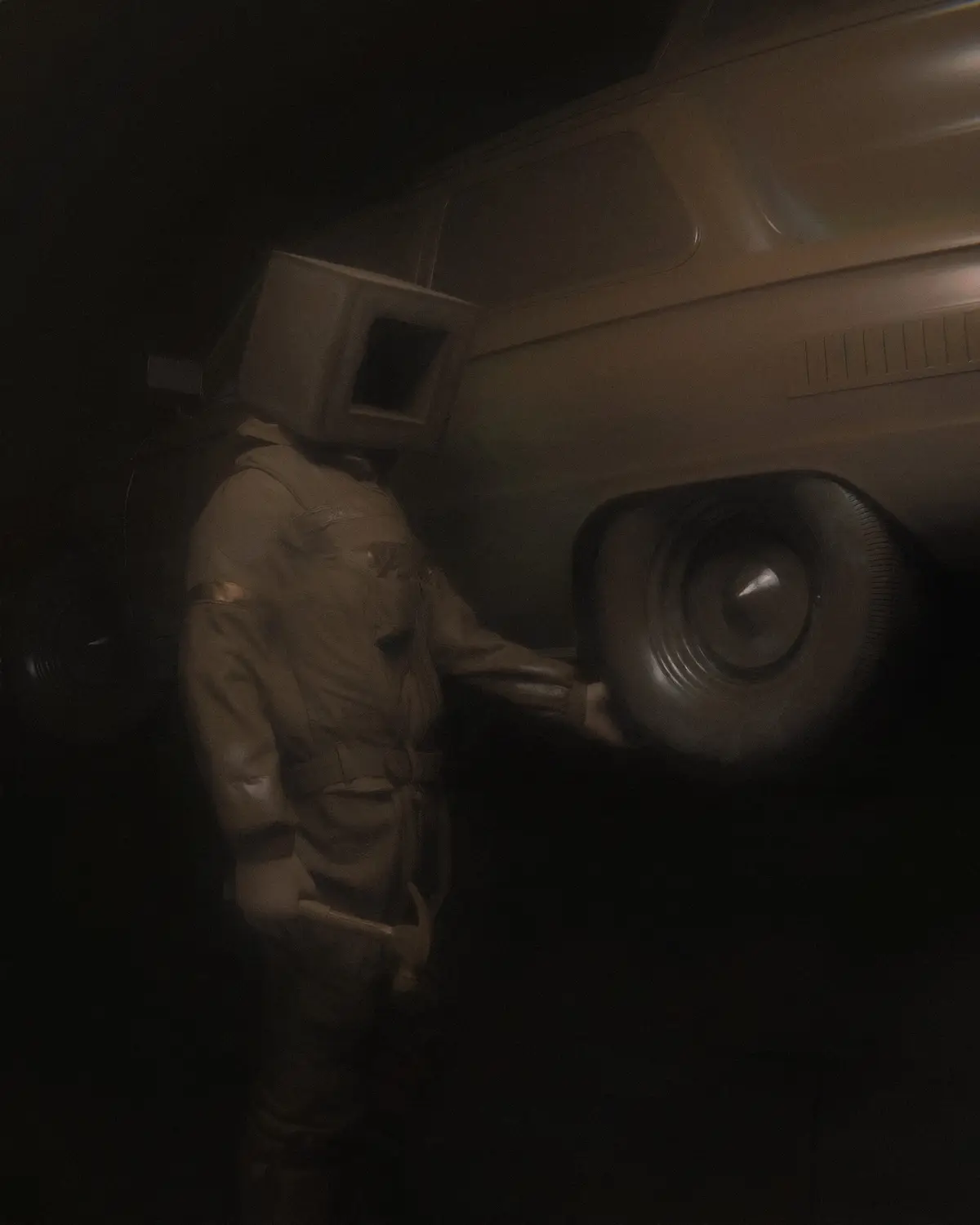 A person wearing a beige jumpsuit and a vintage CRT computer monitor for a head stands in a dimly lit, dusty garage next to…