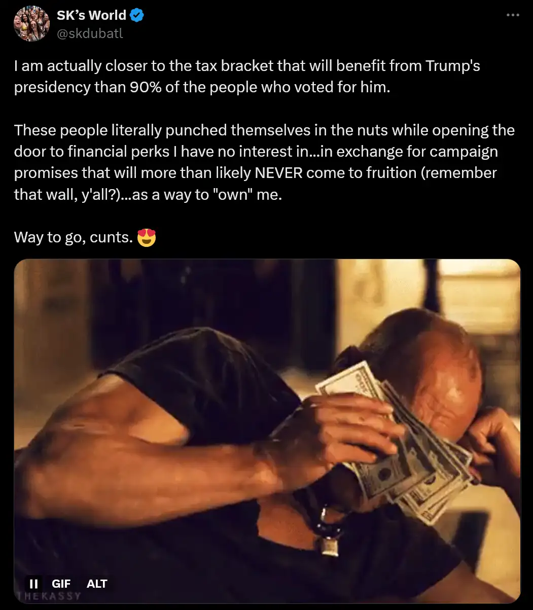 A man with a bald head and muscular arms is shown lying down, holding a wad of US dollar bills to his face, obscuring it…