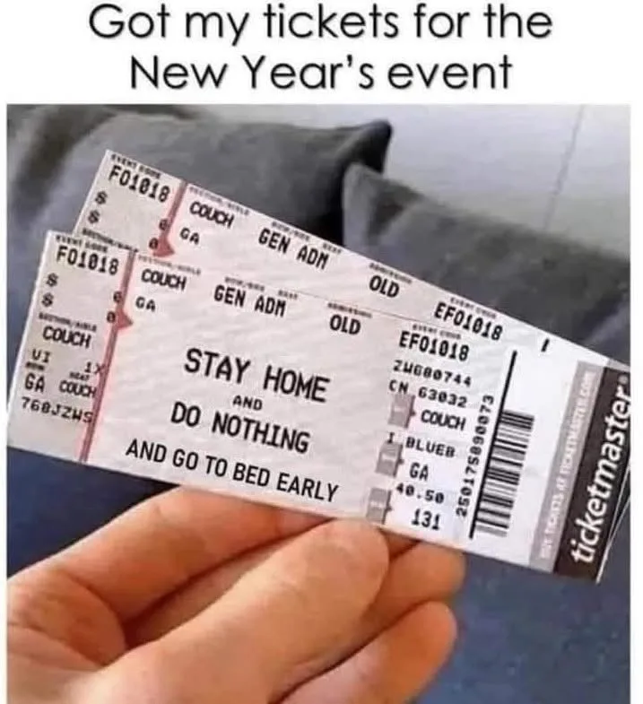 A hand holds two mock concert tickets from Ticketmaster, printed with 'STAY HOME AND DO NOTHING AND GO TO BED EARLY' instead…