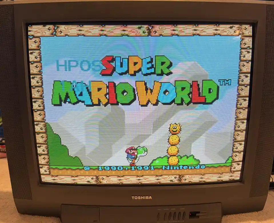 A photo of a CRT television displaying the title screen of Super Mario World, which has been digitally altered to show the…