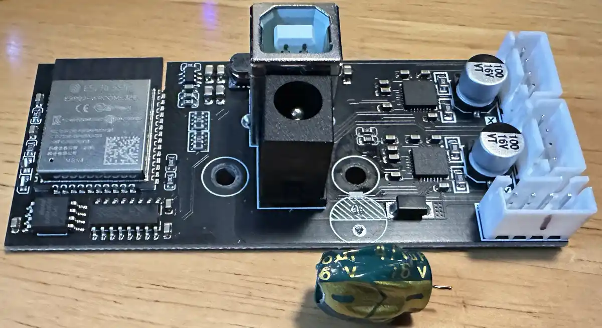 A close-up photo of an electronic circuit board with various components, including capacitors and a USB port, resting on a…