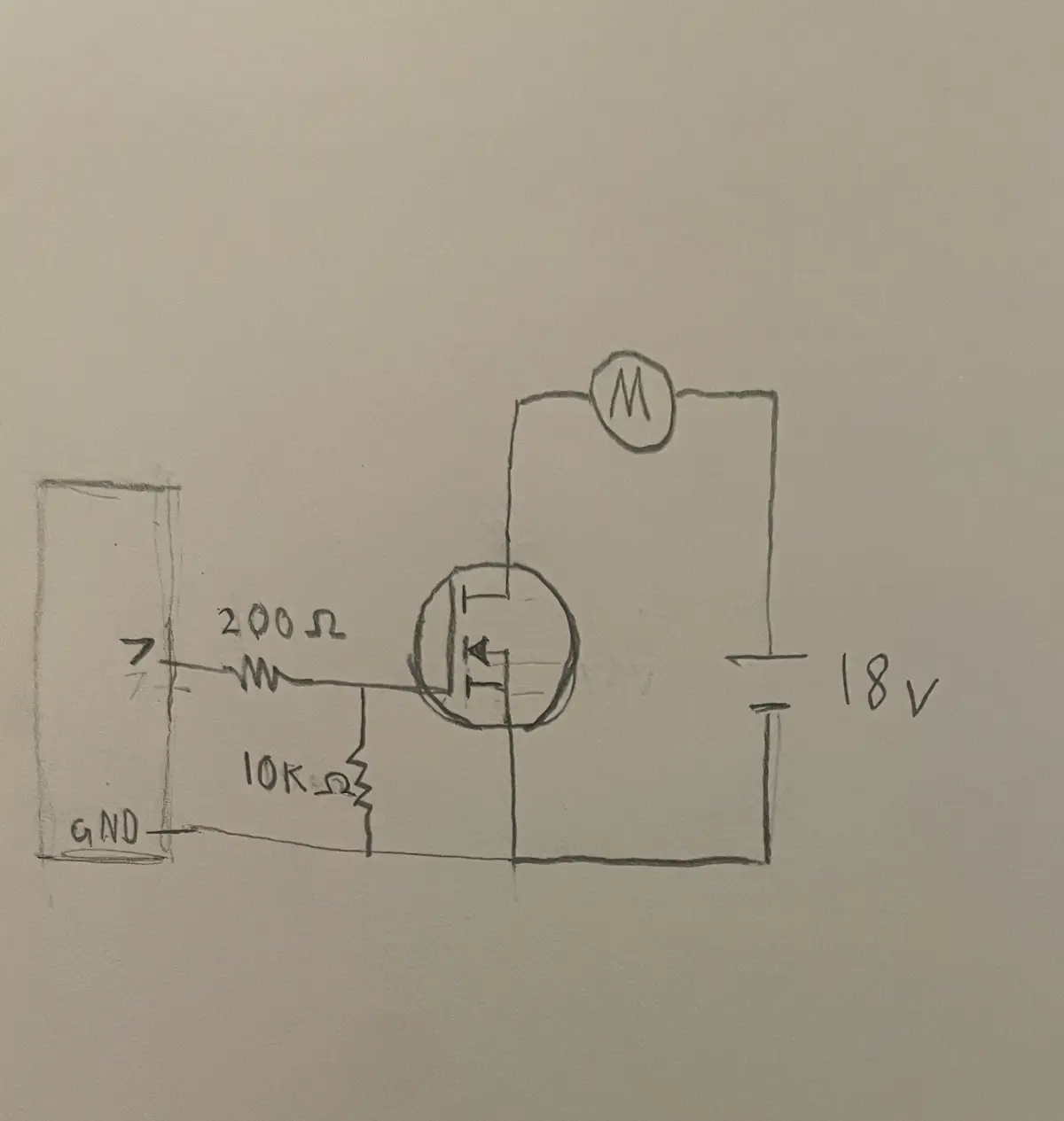 A hand-drawn schematic on paper shows a circuit with an 18V battery, a motor labeled 'M', a transistor, and two resistors…