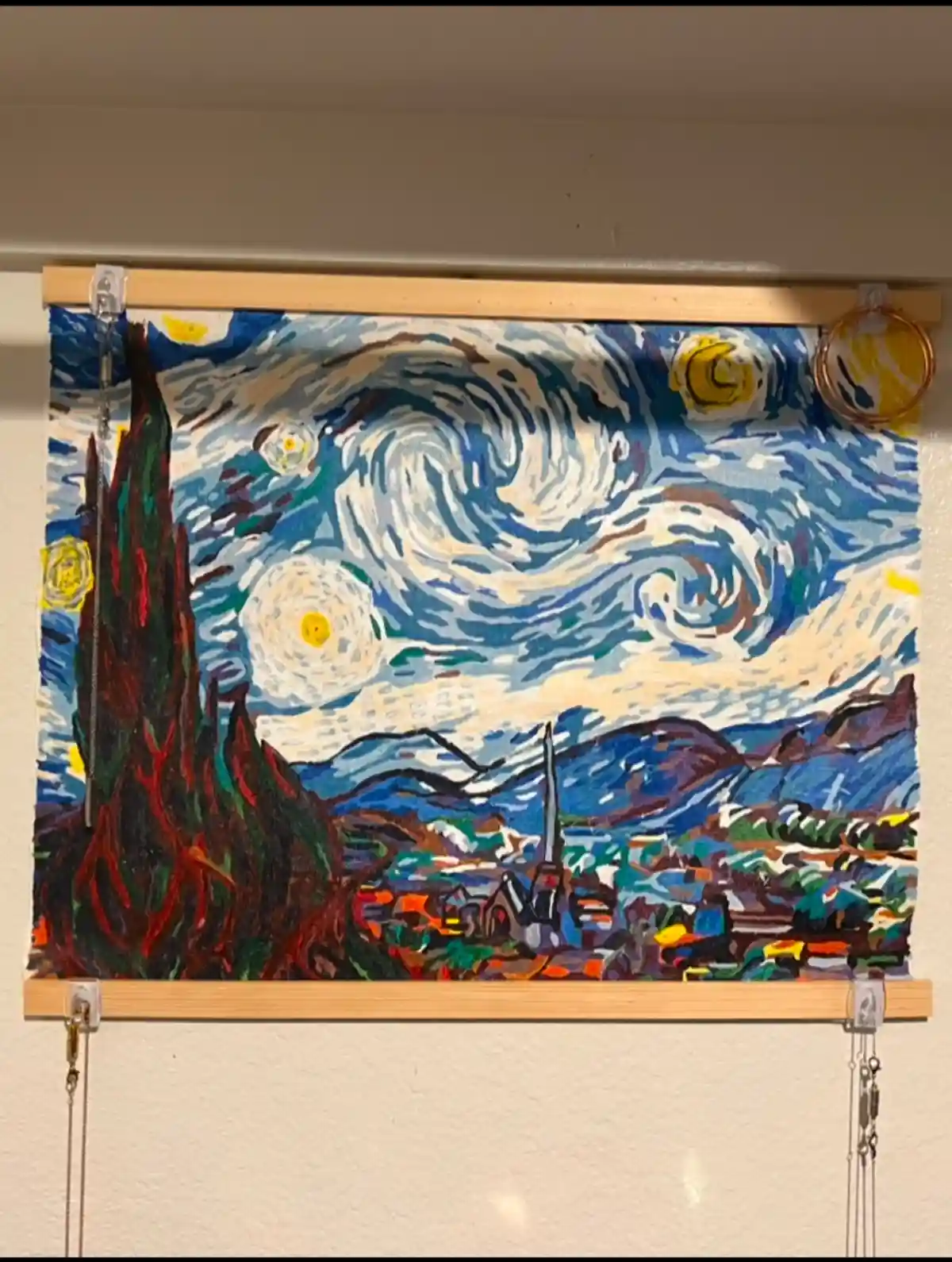 A painting of Vincent van Gogh's 'Starry Night' is displayed as a window blind, with the swirling night sky and cypress tree…