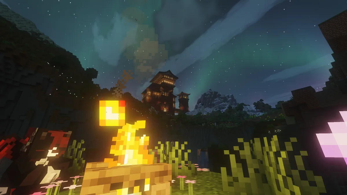 A Minecraft scene at night with a campfire in the foreground, a player character partially visible, and a large, ornate…