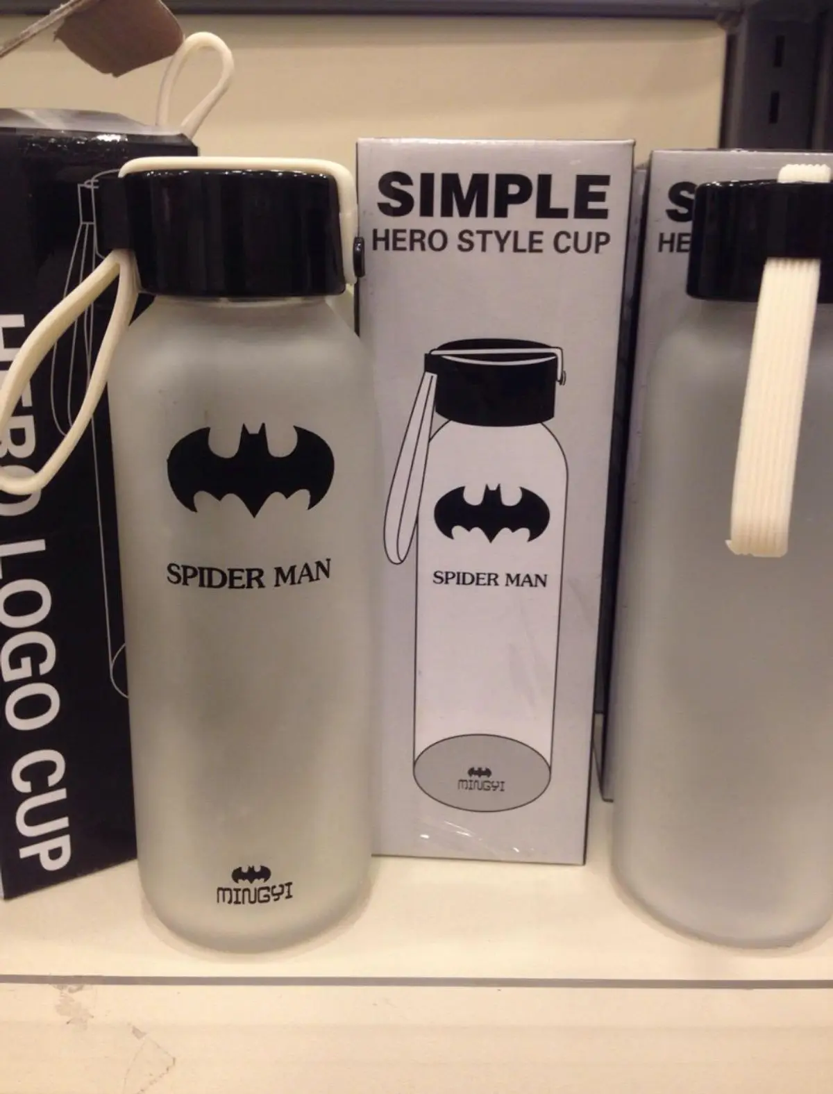 A frosted water bottle with a Batman logo and the text 'SPIDER MAN' is displayed on a shelf next to its box labeled 'SIMPLE…