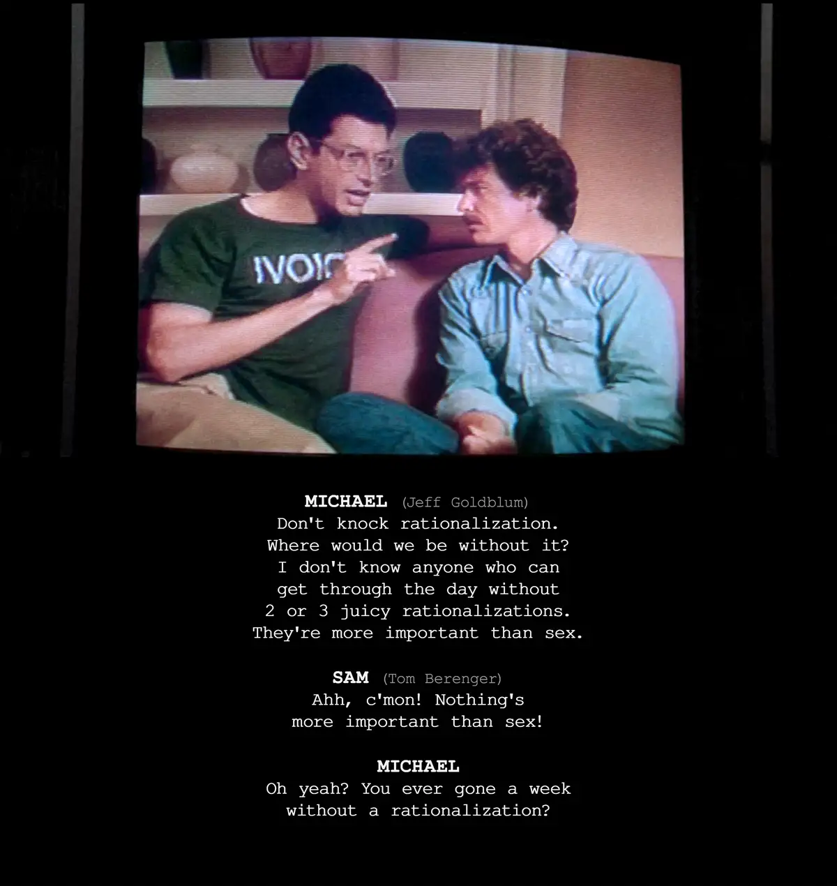 A still from the movie 'The Fly' shows two men sitting on a couch, one in a green t-shirt pointing at the other. Overlaid…
