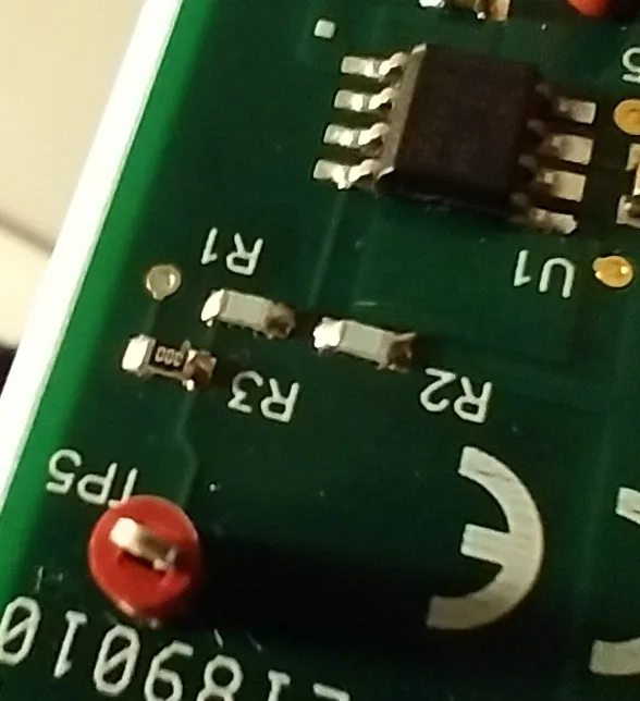 A close-up photo of a green circuit board with labeled electronic components, including resistors R1, R2, and R3, and an…