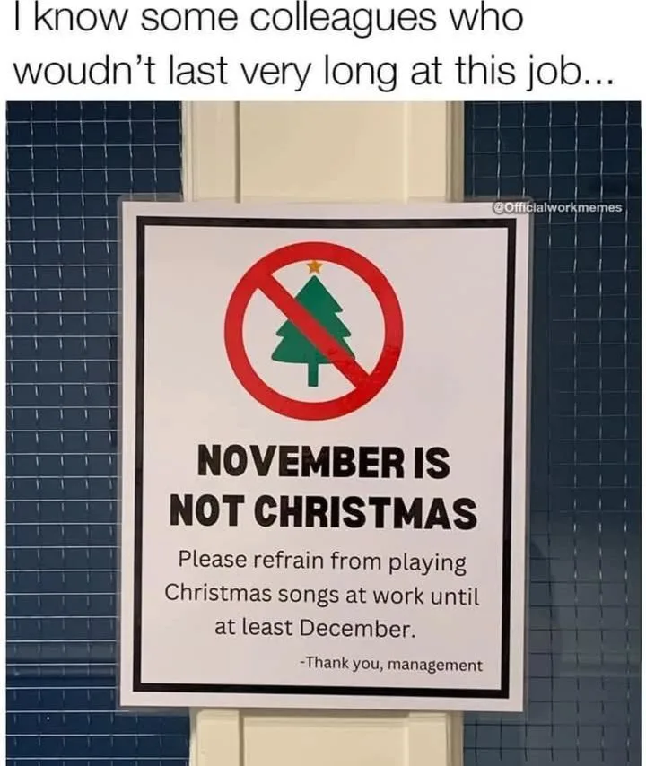 A sign posted on a door with a red circle and slash over a green Christmas tree icon, stating 'NOVEMBER IS NOT CHRISTMAS'…