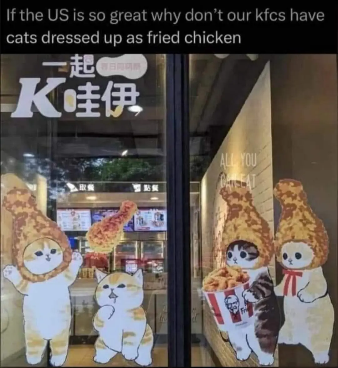 The image shows a storefront window with cartoon cat cutouts dressed in fried chicken costumes. Two cats wear full chicken…