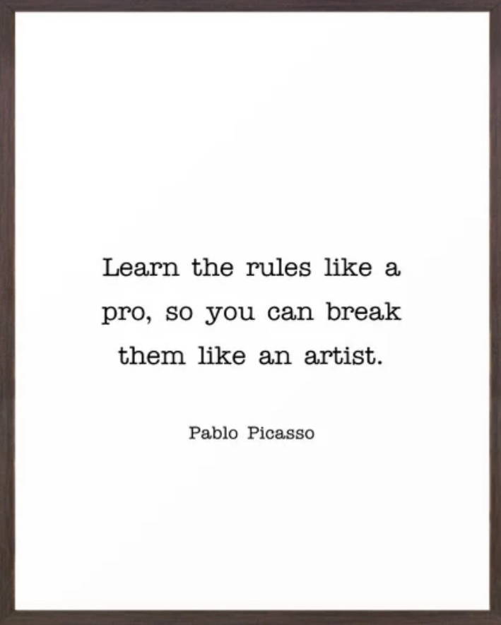 A framed white poster displays the quote 'Learn the rules like a pro, so you can break them like an artist.' attributed to…